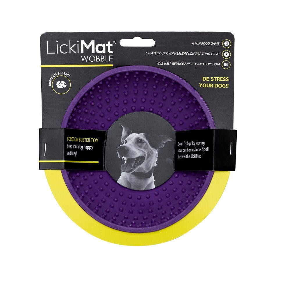 A purple rubber bowl with small nubs inside and a packing band around the LickiMat.