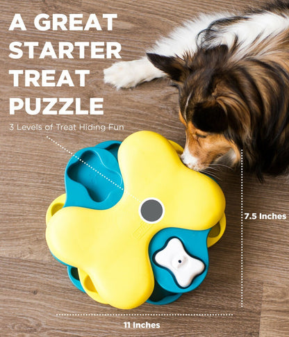 A dog searching for treats in three layers of bone-shaped dog treat puzzles are stacked on each other.